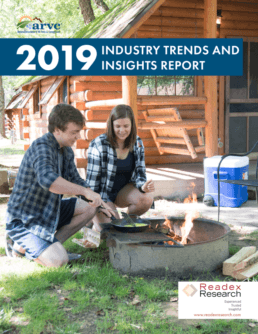 The front cover for the 2019 ARVC Industry Trends & Insights Report shows a picture of a man and a woman kneeling in the grass beside a campfire in front of a cabin. The man is cooking eggs in a frying pan over the fire while the woman watches.