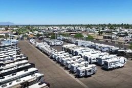 An aerial photograph of an RV dealership lot with dozens of RVs lined up neatly