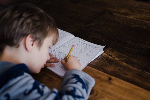 a photo of a little boy filling out a worksheet