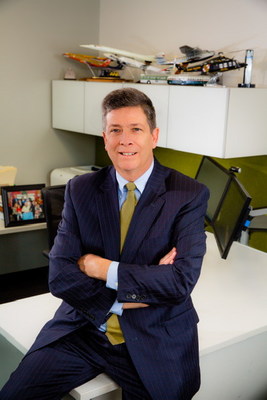 A picture of Port Envoy John Porcari sitting on the corner of an office desk