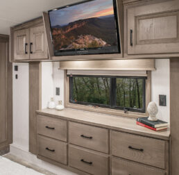 A picture of the bedroom's Chai Hickory style of the 2022 DRV Mobile Suites luxury fifth wheels