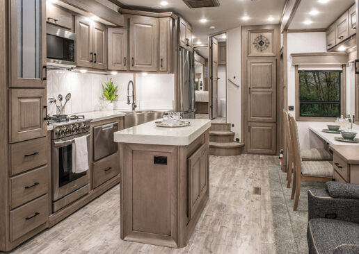 A picture of the interior kitchen Chai Hickory style of the 2022 DRV Mobile Suites luxury fifth wheels