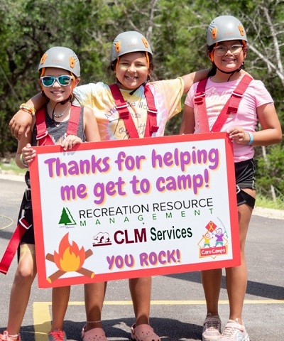 A picture of three Cares Camp campers holding a sign thanking RRM-CLM Services for their recent donation