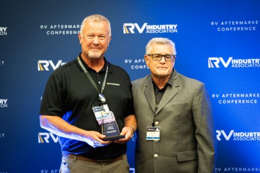 A picture of Stromberg Carlson Bob Brammer (L) holding the Chairman's Award next to Aftermarket Committee Chair John Tinghitella (R).