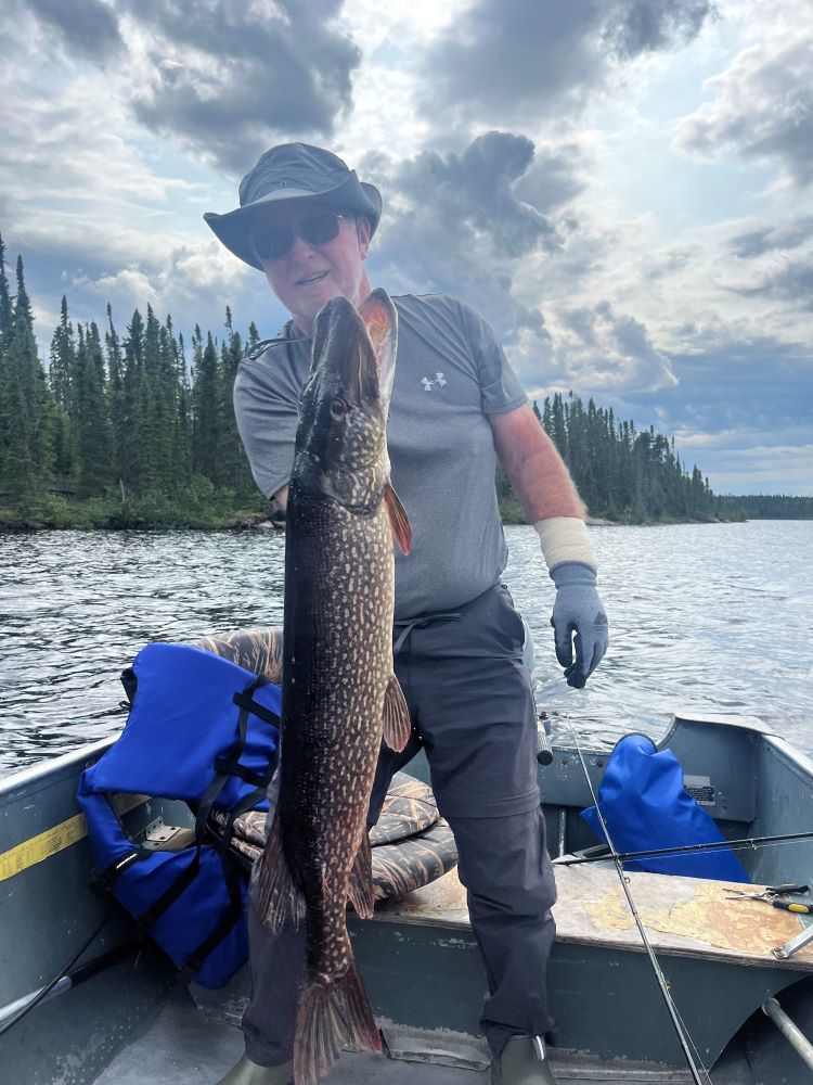 A picture of RV/MH Hall of Fame President Darryl Searer holding a fish.