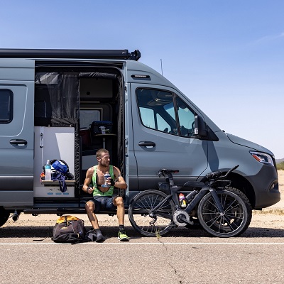 A picture of new Winnebago influencer and partner Lionel Sanders sitting in the door of a Revel Type B motorhome