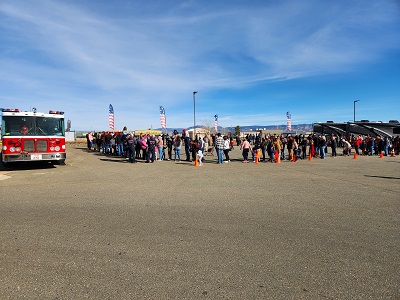 A picture of a line of people waiting to pick up toys and food during Little Dealer Little Prices Christmas donation event.