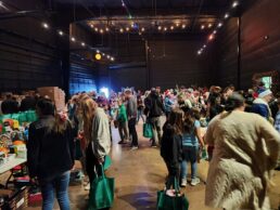 A picture of people gathering around tables inside the Little Dealer Little Prices Christmas donation event in Prescott Valley, Arizona.