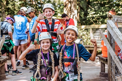 A picture of three children standing on a bridge at a Care Camps event.