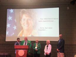 A picture of Jackie Walorski on a big screen as her family accepts the 2023 Darryl Searer Service Award.