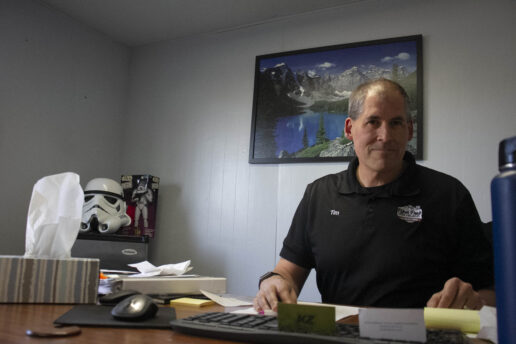 A picture of Tim Biles seated at his desk inside Pikes Peak Traveland RV.