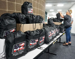 Christen Heerschop reviews some of the 73 backpacks donated by KZ to area elementary school teachers.