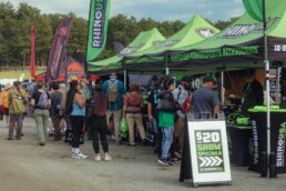 A picture of attendees gathered at a vendor tent at the Overland Expo East event in Virginia.