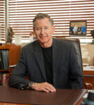 A pipcture of ASA Electronics CEO Thomas Irions seated at his desk.