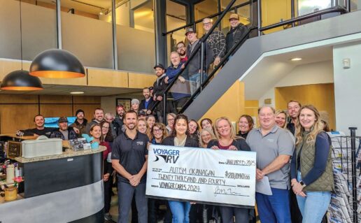 A picture of Voyager RV staff holding a giant check for charity through its Voyager Cares Initiative.